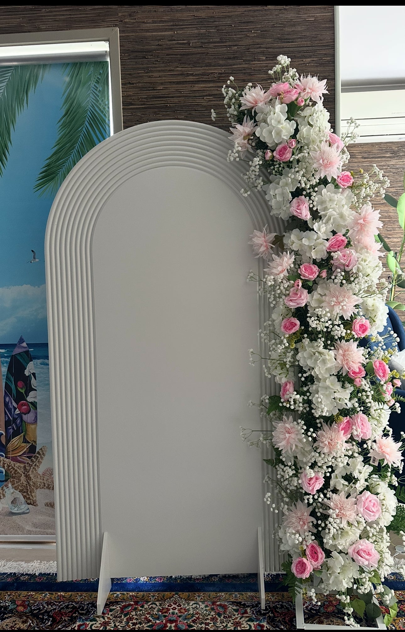 Decorative arch with pink and white flowers against a plain background